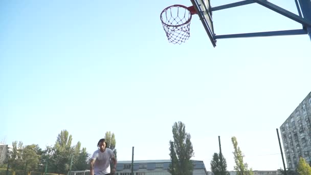 Молодой парень бросает мяч в баскетбольную сетку . — стоковое видео