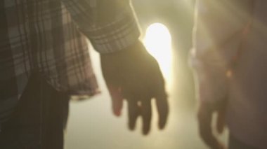 Erkek ve kadın ellerini birbirine günbatımı üzerinde tutun