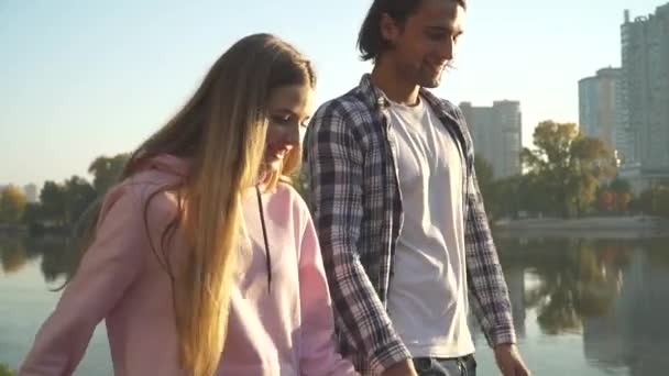 Mladý pár v lásce chodí u jezera — Stock video