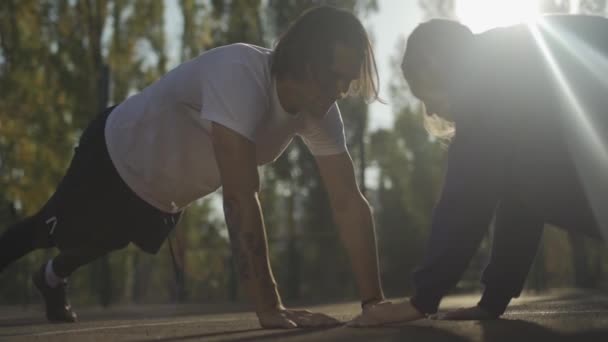 Chico y chica flexiones al aire libre — Vídeos de Stock