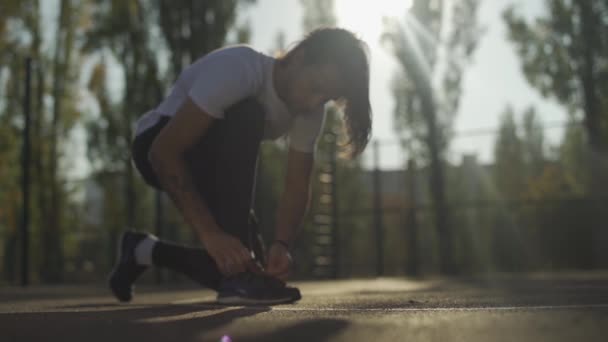 Bonito cara laços até seus tênis ao ar livre — Vídeo de Stock