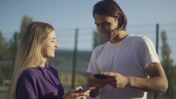 Чоловіки і жінки спілкуються один з одним з телефонами в руках наші двері — стокове відео