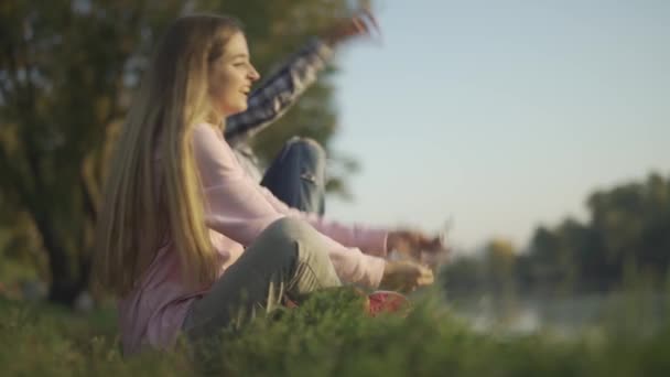 Manliga och kvinnliga sitter på Älvstranden — Stockvideo