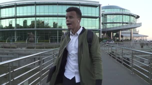 Glücklicher afrikanisch-amerikanischer Kerl mit Kopfhörern, der unterwegs tanzt — Stockvideo