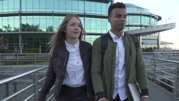 Afrikanisch-amerikanischer Mann und kaukasisches Mädchen sind auf dem Hintergrund des Business Center — Stockvideo