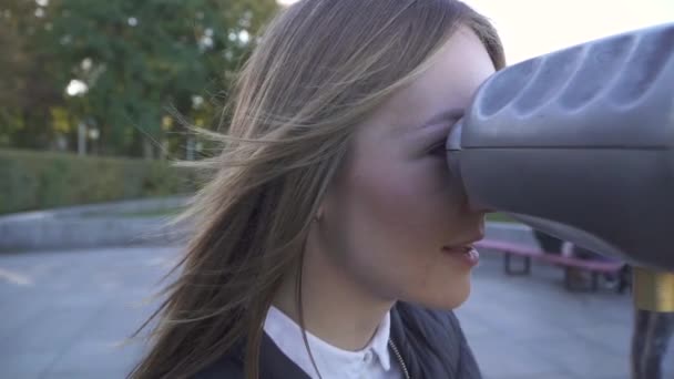 Aranyos nő úgy néz ki, a binokuláris viewer az utca-és városrészlet. — Stock videók