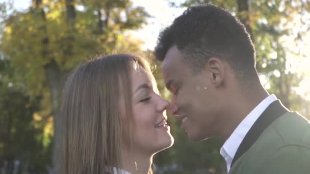 Межрасовая пара целуется на открытом воздухе — стоковое видео