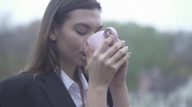 Güzel kadın sıcak kahve açık havada bir kaba elleri ile bir fincan bir kız portresi içme kız içecekler