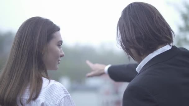 Jovem masculino mostra mulher vista da cidade Jovem casal ao ar livre Cara e namorada passar o tempo juntos — Vídeo de Stock