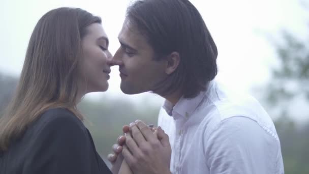 Schöner Mann küsst Frau und hält ihre Hände im Freien Kerl und Freundin verbringen Zeit zusammen Paar in Liebe glückliches Paar — Stockvideo