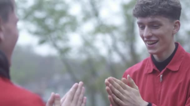 Deux hommes jouent jeu enfants applaudissant les uns les autres mains à l'extérieur amis passer du temps en plein air ensemble amitié masculine — Video