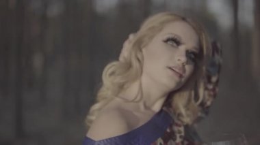 Sahte kirpik sarışın yeşil gözlü güzel kadın sarışın kadının saçını yakın düzeltme portresi var ve uzun kirpik kız yaz aylarında açık havada çıplak omuz içki şarap ile elbise. S-günlük