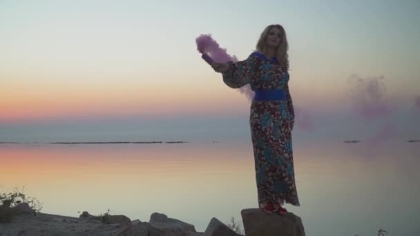 Lief meisje die dat een roze rookbom vrouw staat op de rots mooi meisje in een zomerjurk met een blote schouder leuke vrouw loopt buiten meisje in zomerjurk met blote schouder dranken wijn — Stockvideo