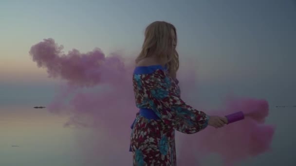 Sweet girl holding a pink smoke bomb Woman is standing on the rock Lovely girl in a summer dress with a bare shoulder Cute woman walks outdoors Girl in summer dress with bare shoulder drinks wine — Wideo stockowe