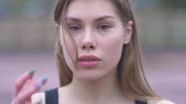 Güzel bir genç kız portresi saçları açık havada fotoğraf makinesi ile güzel gözlerini ve ihale dudaklar genç kızla flört düzeltiyor