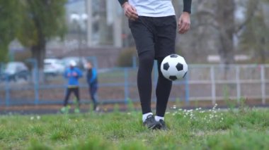 Erkek ayak açık havada futbol topuyla oynuyor. Bacaklar topu egzersizleri Stadyumu sağlıklı yaşam tarzı pratik bir adam