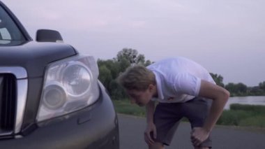 Sarışın adam kırık araba üç kişinin şirket var arkadaşlar var trafik kazası bir eğlenceli birlikte tamir etmeye çalışıyor. Araba arızası