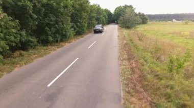 Modern araba kırsal yol biniyor. İnsanlar arabayla seyahat. Manzara yolun şehir dışında. Havadan çekim. Drone çekim