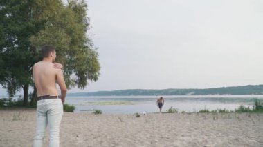 İki adam bir futbol topuyla Nehri yakınında sahilde top ile arkadaşları hakkına açık havada iki arkadaş eğlenceli bir birlikte zaman açık havada aktif yaşam tarzı harcama oynayan