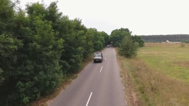 Σύγχρονο αυτοκίνητο είναι ιππασία υπαίθρου δρόμο άτομα ταξιδεύουν με το αυτοκίνητο από το drone τα γυρίσματα — Αρχείο Βίντεο