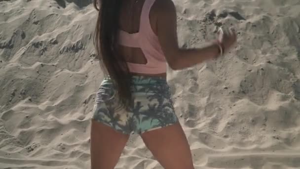 Mulher quente dançando twerk na praia Menina bronzeada move sua bunda de pé na areia Mulher bonito está dançando em shorts curtos ourdoors — Vídeo de Stock