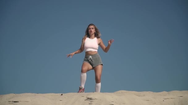 Passionerad tjej dansar twerk på stranden garvade flickan i korta shorts flyttar hennes kropp står på sand honan är twerking utomhus Pretty lady danser hot — Stockvideo