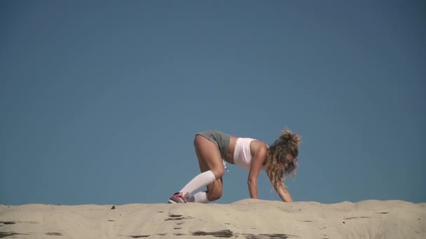Сексуальна гаряча жінка танцює twerk на пляжі Засмагла дівчина в коротких шортах рухає її тіло на піску Жінка тверда на відкритому повітрі Гарненька леді танцює пристрасно — стокове відео