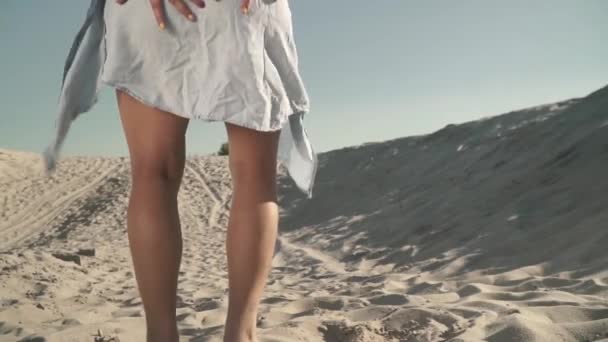 Jeune femme sexy à la plage Femme chaude aux cheveux longs et foncés s'assoit lentement sur le sable — Video