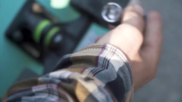 Erkek el bir kaykay sabitleme closeup. Çapraz-tekerlekler için anahtar. — Stok video