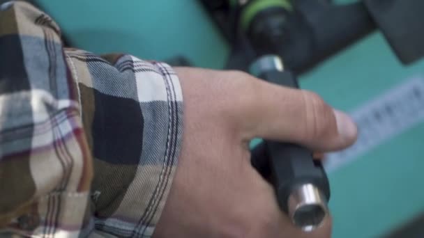 Tot vaststelling van een skateboard-close-up mannenhand. Cross-verdeelsleutel voor de wielen. — Stockvideo