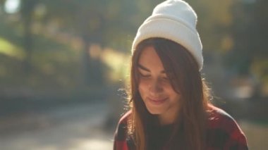 Bir beyaz şapka ve ekose gömlek gülümseyen genç hippi kız portresi. Sevimli kız açık havada güneş altında.