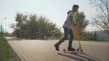 Çocuk açık havada scooter sürme. Çocuk bir kağıt uçak park başlattı