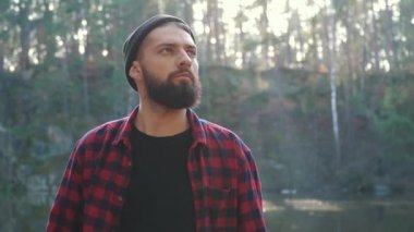 Genç adam bir balta yürüyüş ormandaki ile sakallı. Açık havada bir balta ile tıraşsız forester.