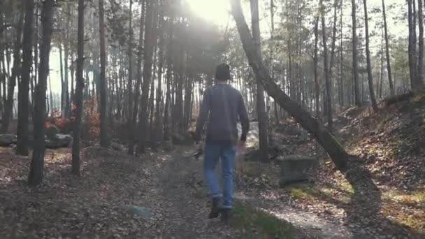 En man går i skogen WiFin med en yxa i händerna. Forester med en yxa utomhus. — Stockvideo