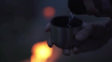 Termos yangın yakınındaki bir su bardağı koymak eller mans. Forester orman yangında tarafından.