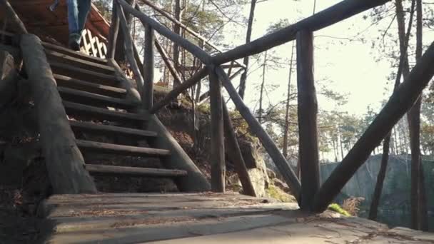 Man walk to a lake by bridge witn an axe in his hand. Guy with an axe outdoors. — Stock Video