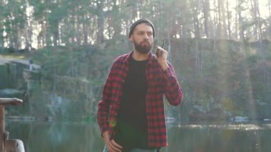 Sakallı ciddi adam ormanda elinde balta ile kal. Acımasız ciddi adam açık havada balta ile.