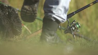Balık çekerek bir iplik bobin yakın çekim Fisher döner. Bir olta kamışı kullanarak balık balıkçı yakalar.