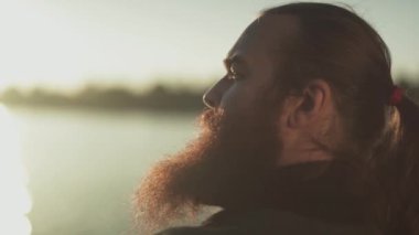 Sunlights içinde uzun sakallı bir adam portresi yakın çekim.