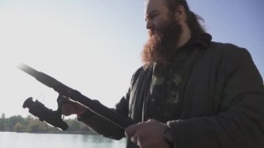 Balıkçı iplik balıkçılık makara. Sakallı adam Nehri üzerinde bir olta ile. Nehir Balık tutma. Ağır çekim.