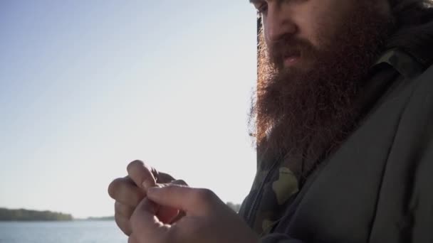 Il pescatore mette un verme sull'amo. Ritratto di uomo adulto con barba che mette la cauzione all'amo. Pesca con esche vive. Pesca sul fiume . — Video Stock