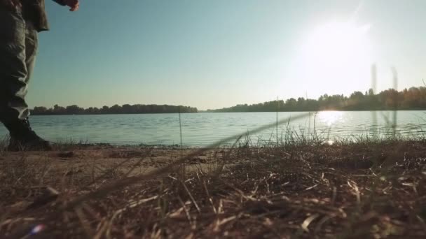 Le gambe dell'uomo camminano vicino al fiume. Gambe maschili che camminano sotto il sole vicino al fiume . — Video Stock