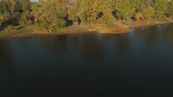 Nehir kıyısında bir olta ile balıkçı abave üzerinden görüntüleyin. Drone çekim. — Stok video
