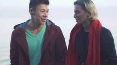 Asya'ya ait adam ve sevimli beyaz kız açık havada sohbet. Rahat kıyafet güzel ırklararası çift doğada rahatlatıcı ve birlikte vakit.