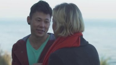 Interracial genç bir tarihi açık havada üzerinde çift. Asya'ya ait adam kız gülümsüyor. Güzel iki rahat kıyafet içinde doğada rahatlatıcı ve birlikte vakit.