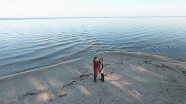 Bir çift yürüyüş kumlu nehir kıyısında üzerinde üst görüntüleyin. İlişki çiftin birlikte vakit. Dron--dan ateş. Ağır çekim.