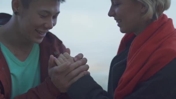 Date des gemischtrassigen Paares im Freien. asiatische Kerl küsst seine kaukasische Freundin. schönes interrassisches Paar in Freizeitkleidung entspannt in der Natur und verbringt Zeit miteinander. — Stockvideo