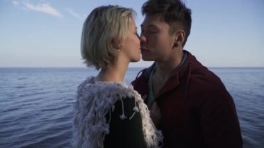 Irklararası çift açık havada öpüşme genç portresi. Asya'ya ait adam ve beyaz kız bir tarihte. Rahat kıyafet güzel ırklararası çift doğada rahatlatıcı ve birlikte vakit. İhale