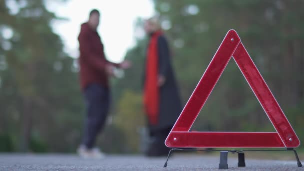 Два Человека Клянутся Фоне Предупреждающего Треугольника — стоковое видео