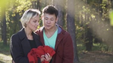 Bir genç çok etnik kaç rahat kıyafetler içinde ormanda güneş ışığı bir arka plan üzerinde yürüyor. İki açık havada eğlence harcama seviyorum. Ağır çekim.